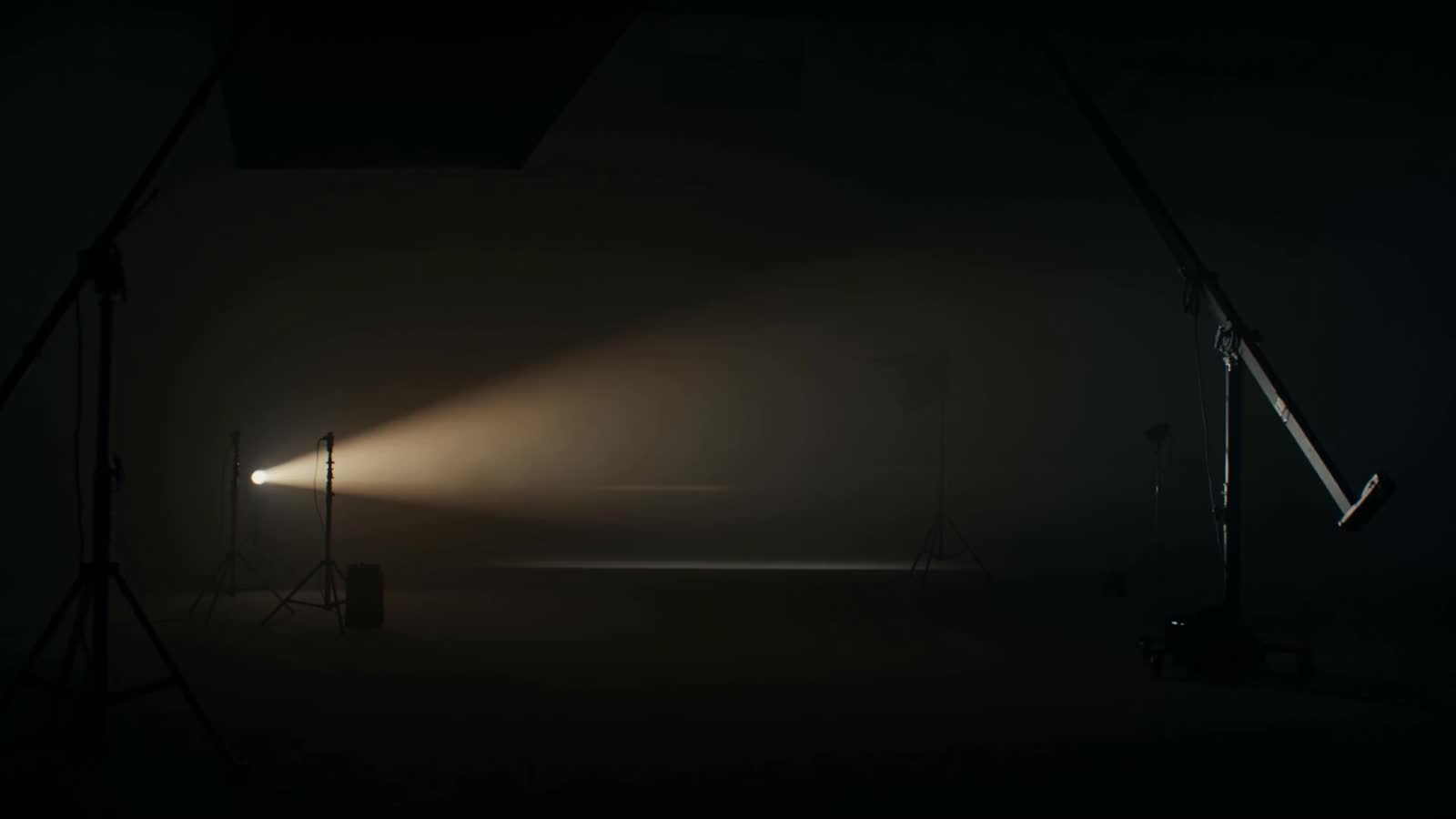 Langsame Kamerafahrt durch ein dunkles Fotostudio im Gegenlicht.